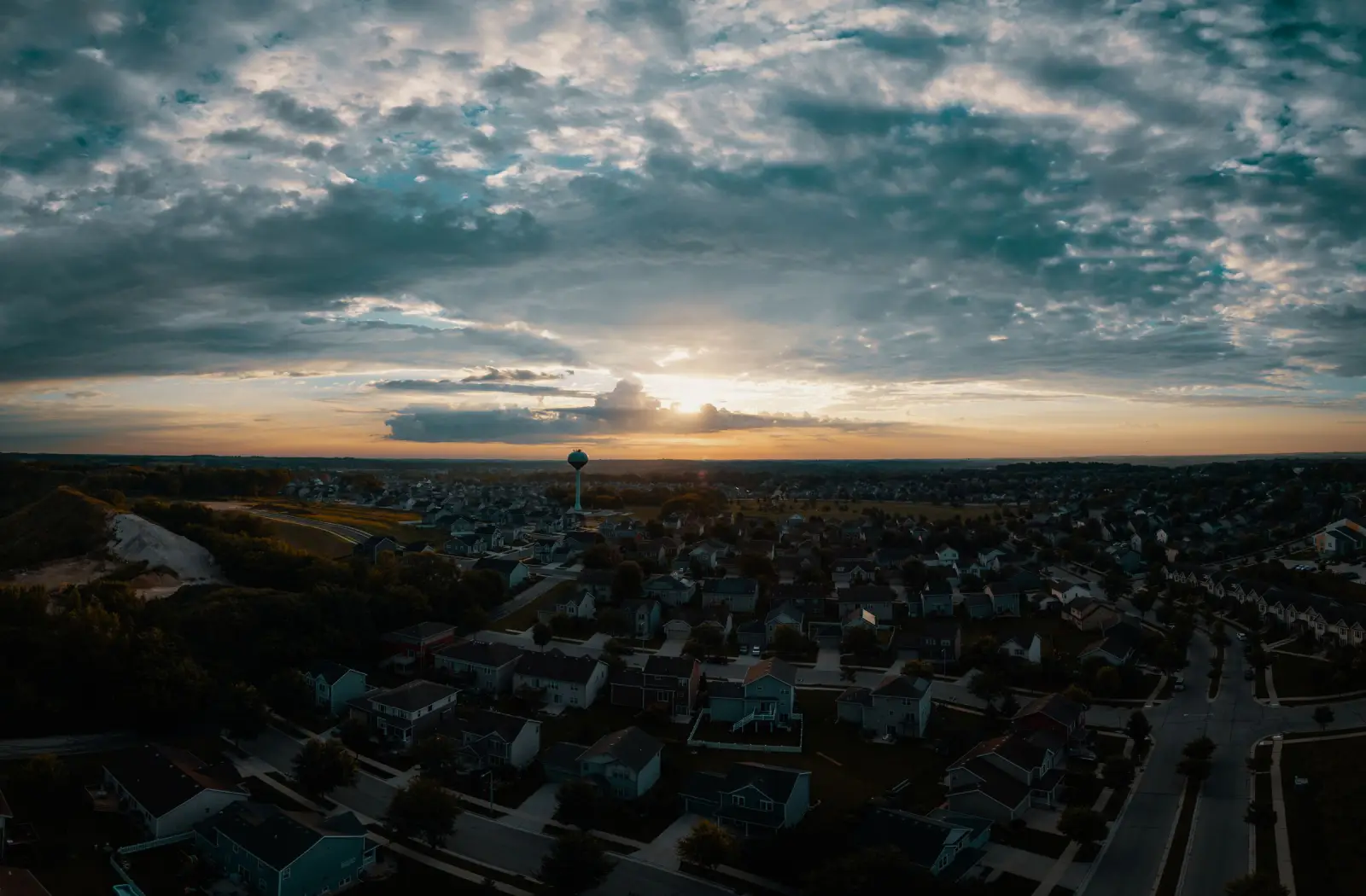 Aerial view of a Midwestern suburban neighborhood and water tower at sunset