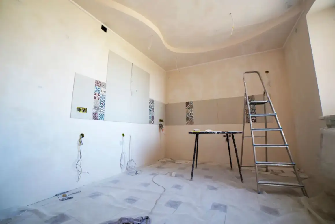 Room set up for ceiling repair with floors covered and finishing tools laid out
