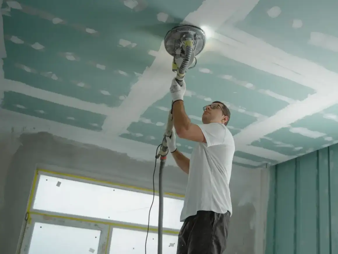 Ceiling drywall sanded smooth overhead during a ceiling repair in Madison