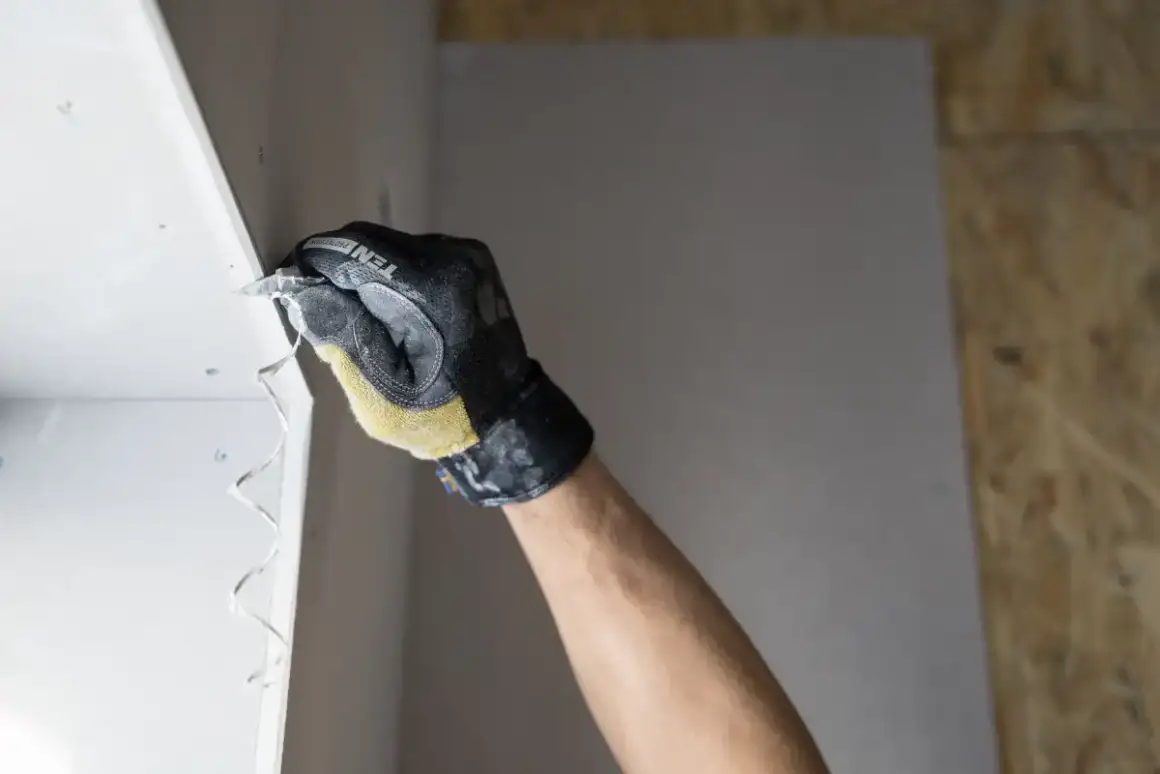 Joint compound worked across a drywall patch with a taping knife on a Madison drywall repair