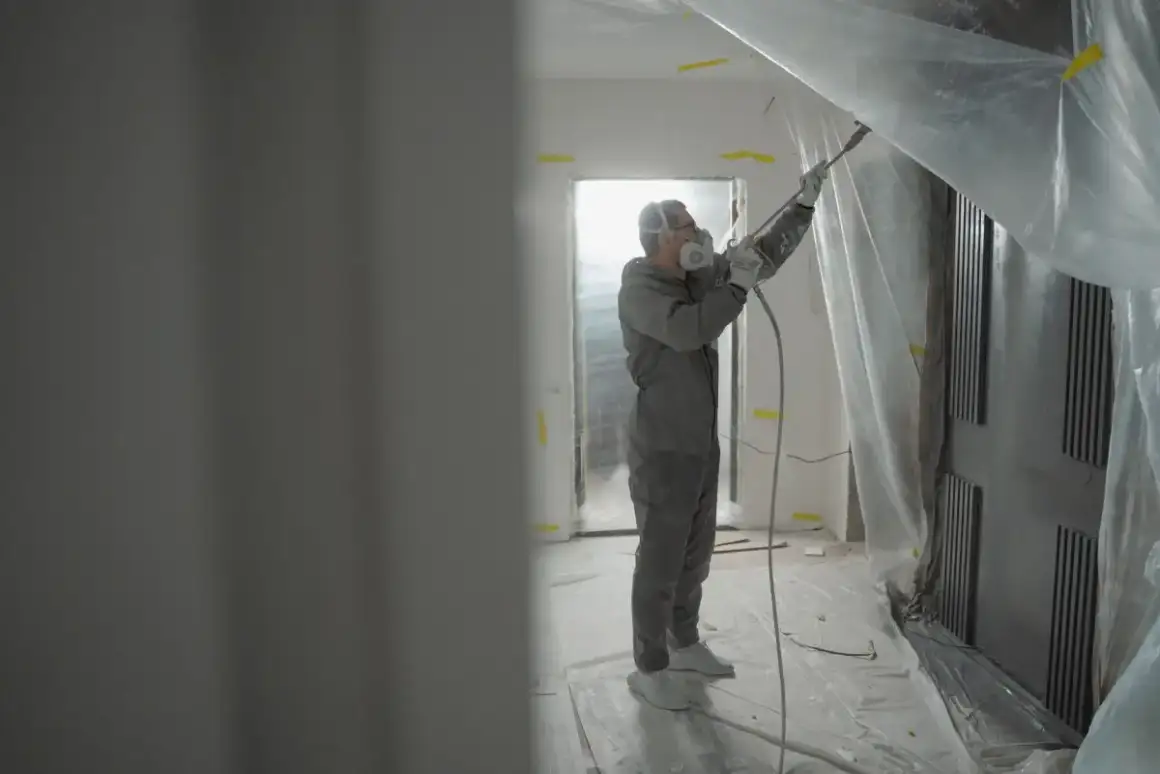 Texture sprayed with the operator in protective gear and the surrounding area masked