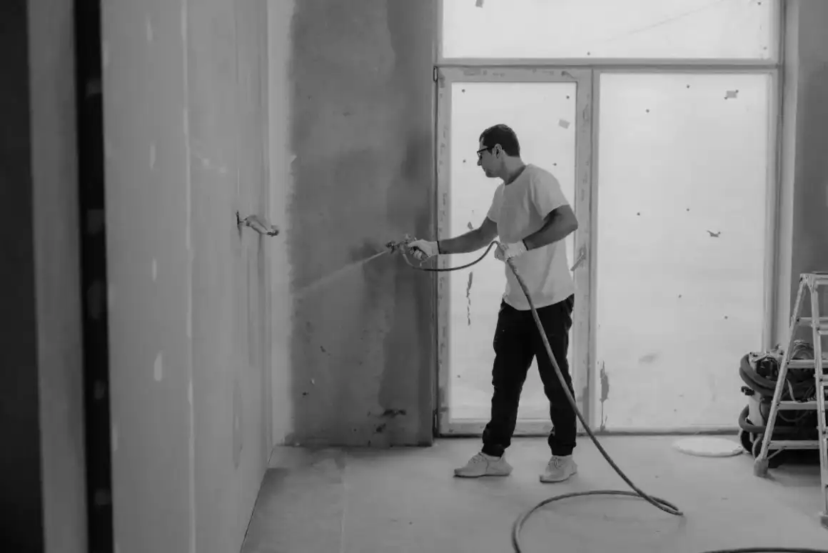 Texture compound sprayed onto a wall through a hopper gun on a Madison drywall texturing job